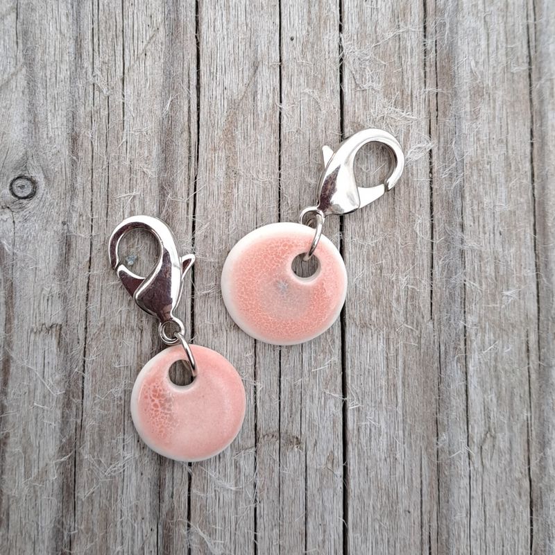 Maskemarkør av porselen rosa og grå med metallfarget krok